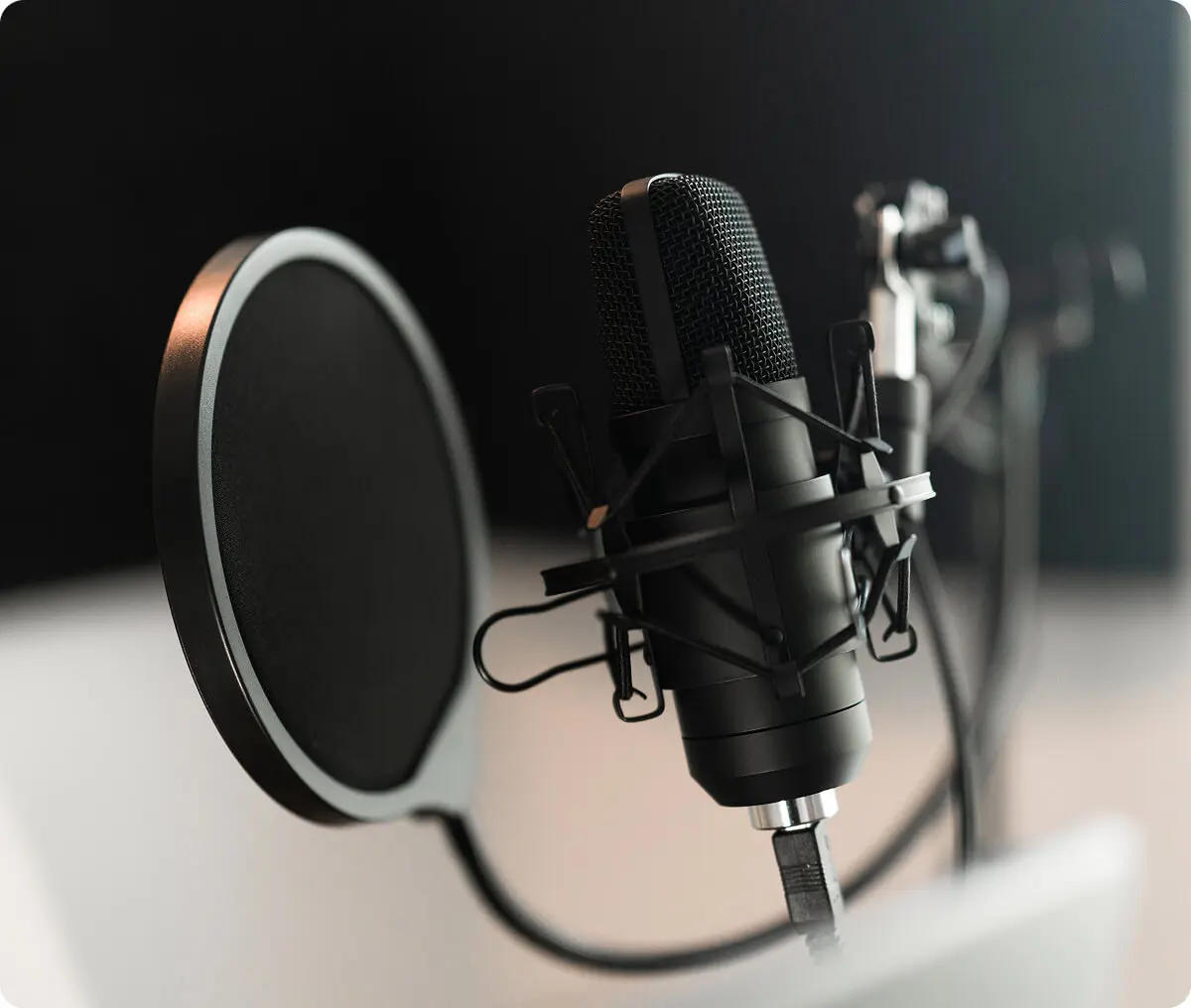 Microphone with pop filter in recording studio.
