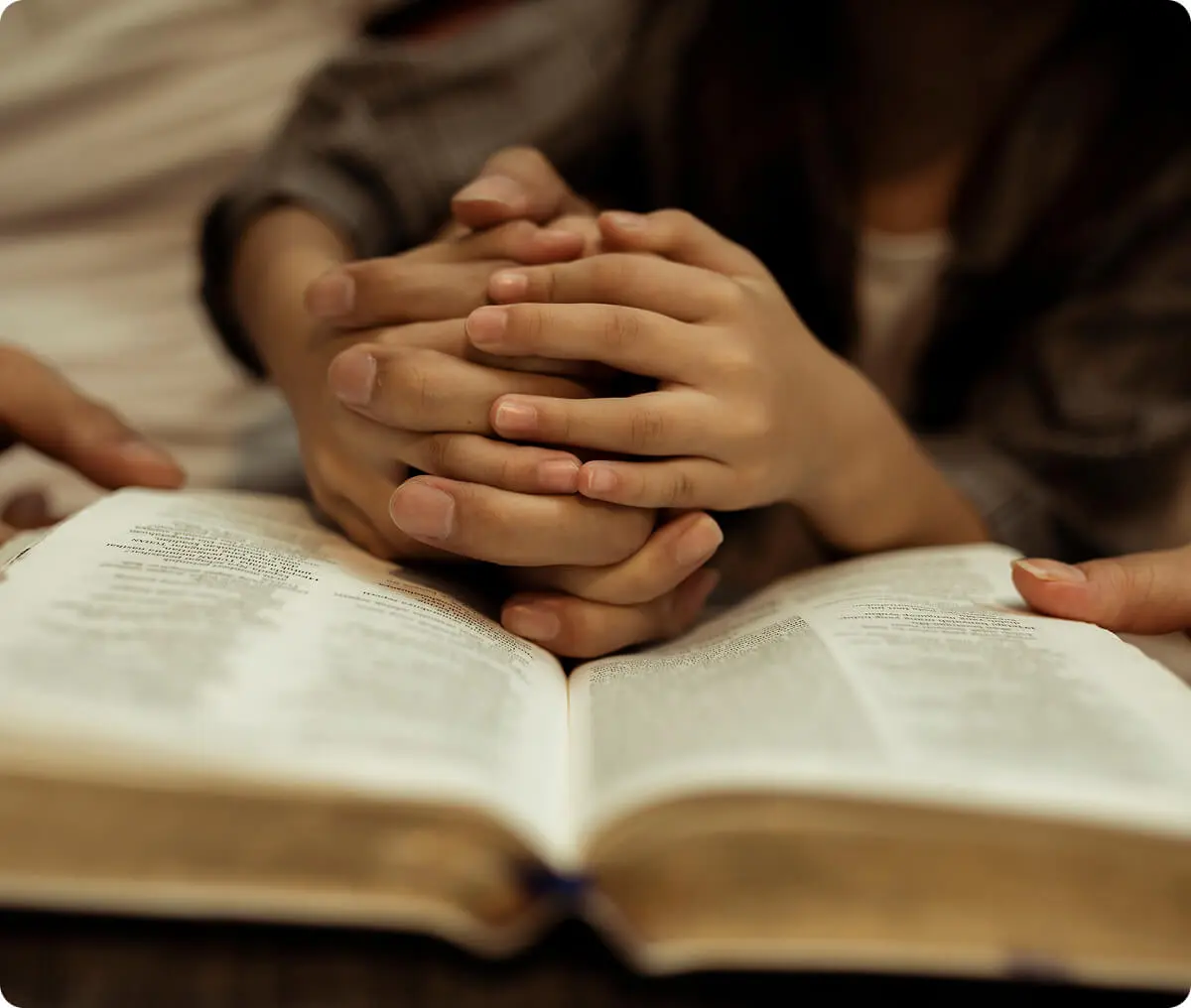 Hands holding over an open book.