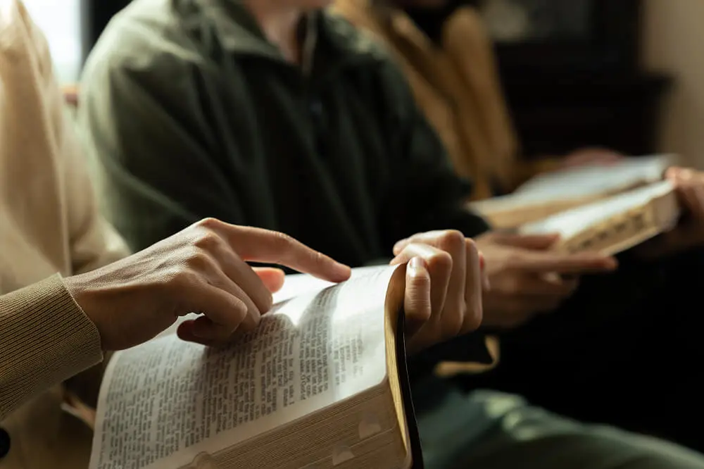 People reading and pointing at open books.
