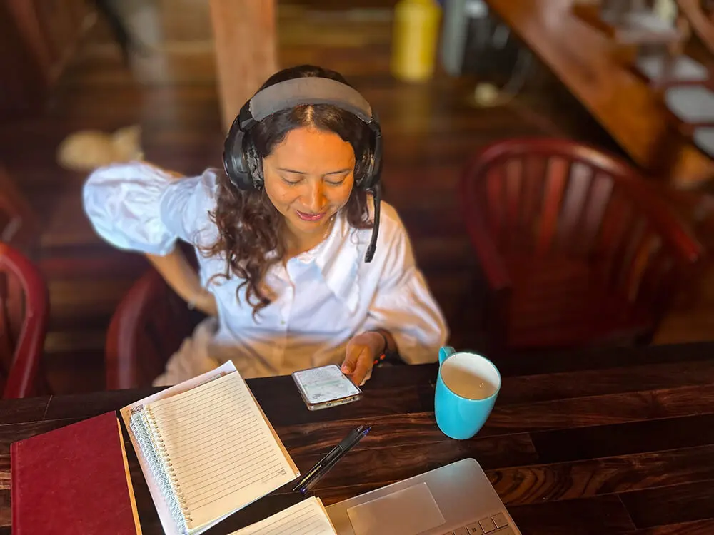 Woman working at desk with headphones on.